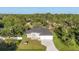 Aerial view of a modern home with a gray roof surrounded by lush greenery at 3694 Crittendon St, North Port, FL 34286