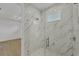 Modern bathroom featuring marble tile, a frameless glass shower, and white tile floors at 3694 Crittendon St, North Port, FL 34286