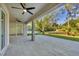 A covered patio features ceiling fans, tiled floors, and serene views of the landscaped backyard at 3694 Crittendon St, North Port, FL 34286