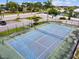 Aerial view of blue and green community tennis court with fenced perimeter and nearby parking at 3718 59Th Ave W # 3718, Bradenton, FL 34210