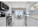 Compact kitchen featuring white cabinets, stainless steel appliances, tile floors, and a breakfast nook with waterfront views at 3859 Catalina Dr, Bradenton, FL 34210