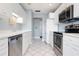 Modern kitchen featuring all-white cabinetry, stainless steel appliances, and diamond-pattern tile floors at 3859 Catalina Dr, Bradenton, FL 34210