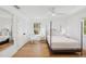 Sunlit bedroom with hardwood floors, backyard views, a modern ceiling fan, and white accents at 4013 Red Rock Ln, Sarasota, FL 34231