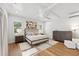 Bedroom featuring hardwood floors, ceiling fan, tray ceiling, and ample natural light at 4013 Red Rock Ln, Sarasota, FL 34231
