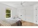 Comfortable bedroom with view of the yard, hardwood flooring, ceiling fan, and white accents at 4013 Red Rock Ln, Sarasota, FL 34231
