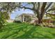 A sprawling front lawn, lush landscaping, and mature trees add to the curb appeal of this exceptional home at 4013 Red Rock Ln, Sarasota, FL 34231