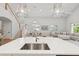 Stylish kitchen showcasing a modern island, with an open view to the dining and living areas, and a staircase nearby at 4013 Red Rock Ln, Sarasota, FL 34231