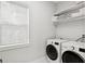 Clean, bright laundry room with modern washer and dryer, convenient shelving and a window at 4013 Red Rock Ln, Sarasota, FL 34231