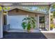 Detached garage featuring an attached carport, white door, and well-kept landscaping at 4019 Worcester Rd, Sarasota, FL 34231