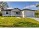 Charming single-story home with manicured lawn and an attached two-car garage at 405 Sunset N Rd, Rotonda West, FL 33947