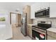 Modern kitchen with stainless steel appliances, light wood cabinets, and white countertops at 405 Sunset N Rd, Rotonda West, FL 33947