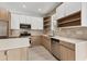Bright kitchen featuring white and wood cabinetry, stainless steel appliances, and open shelving at 405 Sunset N Rd, Rotonda West, FL 33947
