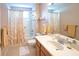 Well-lit bathroom featuring a shower with tub, cream floral shower curtain, and spacious vanity with storage at 4069 Overture Cir # 341, Bradenton, FL 34209