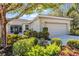 Home exterior featuring lush landscaping, a tile roof, and a screened-in porch, offering both beauty and functionality at 4136 Cascade Falls Dr, Sarasota, FL 34243