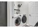 Bright laundry room with white washer and dryer set with utility shelving and storage space at 4136 Cascade Falls Dr, Sarasota, FL 34243