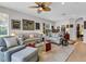 Living room featuring neutral-toned sofas, armchairs, and a glass coffee table beneath a ceiling fan at 4136 Cascade Falls Dr, Sarasota, FL 34243