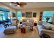 Cozy living room featuring neutral-toned sofas, armchairs, and a glass coffee table beneath a ceiling fan at 4136 Cascade Falls Dr, Sarasota, FL 34243