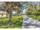 Scenic view of a charming sidewalk through a grassy yard with mature trees and greenery on a sunny day at 4136 Cascade Falls Dr, Sarasota, FL 34243