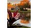 View of a calm pond with lush vegetation and a home in the background at 4136 Cascade Falls Dr, Sarasota, FL 34243