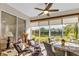 Bright sunroom featuring tile floors, modern furniture, and stunning water views at 4136 Cascade Falls Dr, Sarasota, FL 34243