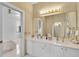 Upscale bathroom with double vanity, gold accents, and a view into an adjacent bedroom at 4146 Westbourne Cir, Sarasota, FL 34238
