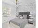 A modern bedroom features geometric wallpaper, neutral bedding, and sleek nightstands at 4146 Westbourne Cir, Sarasota, FL 34238