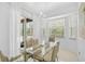 Bright dining room with glass table and tan chairs with great natural lighting and view of outdoors at 4146 Westbourne Cir, Sarasota, FL 34238