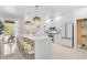 Bright, all-white kitchen features an island with seating and stainless steel appliances at 4146 Westbourne Cir, Sarasota, FL 34238