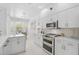 Modern kitchen features stainless appliances, white cabinets, and an attached dining area at 4146 Westbourne Cir, Sarasota, FL 34238