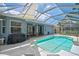 Screened-in pool featuring an attached spa, outdoor seating, and grill, offering a perfect backyard retreat at 4146 Westbourne Cir, Sarasota, FL 34238