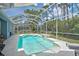 A sparkling screened-in pool with an attached spa, surrounded by lush landscaping and patio space at 4146 Westbourne Cir, Sarasota, FL 34238