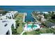 Aerial view of waterfront condos, a pool area, boat docks, and a canal at 450 Gulf Of Mexico Dr # B207, Longboat Key, FL 34228