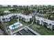 Aerial view of waterfront condos with a pool and boat dock, surrounded by lush landscaping and beautiful views at 450 Gulf Of Mexico Dr # B207, Longboat Key, FL 34228