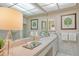 Bright bathroom with vanity, framed mirror, and decorative leaf art at 450 Gulf Of Mexico Dr # B207, Longboat Key, FL 34228