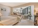 Spacious bedroom with sitting area and a view of the outside balcony and water at 450 Gulf Of Mexico Dr # B207, Longboat Key, FL 34228
