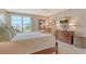 Comfortable bedroom with scenic views, dresser with lamps and mirror, and flat screen TV at 450 Gulf Of Mexico Dr # B207, Longboat Key, FL 34228
