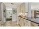 Well-lit kitchen featuring white cabinets, black countertops, stainless appliances and tile flooring at 450 Gulf Of Mexico Dr # B207, Longboat Key, FL 34228