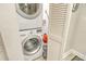 Laundry closet with stacked washer and dryer units, and bifold door at 450 Gulf Of Mexico Dr # B207, Longboat Key, FL 34228