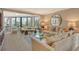 Bright living room with plush seating, modern decor, and a full wall of windows with natural light at 450 Gulf Of Mexico Dr # B207, Longboat Key, FL 34228
