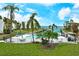 Beautiful pool area with lush landscaping, palm trees, and waterfront views at 450 Gulf Of Mexico Dr # B207, Longboat Key, FL 34228