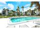 Large outdoor pool surrounded by lounge chairs, palm trees, and condo buildings at 450 Gulf Of Mexico Dr # B207, Longboat Key, FL 34228