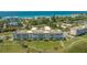 Aerial view showcasing beach, mature trees, and complex grounds on a sunny day at 4760 Gulf Of Mexico Dr. Villa 7, Longboat Key, FL 34228