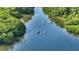 Scenic aerial view of kayakers peacefully navigating a waterway surrounded by lush green trees at 4760 Gulf Of Mexico Dr. Villa 7, Longboat Key, FL 34228