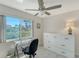 Bright room with a ceiling fan, large window, and a dresser next to a desk at 4760 Gulf Of Mexico Dr. Villa 7, Longboat Key, FL 34228
