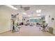 Bright fitness center featuring treadmills, weight machines, and large windows overlooking lush outdoor scenery at 4760 Gulf Of Mexico Dr. Villa 7, Longboat Key, FL 34228