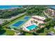 Community pool and tennis courts surrounded by lush landscaping at 4760 Gulf Of Mexico Dr. Villa 7, Longboat Key, FL 34228