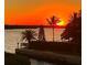 Breathtaking sunset over the water with palm trees and tranquil scenery at this lovely property at 4760 Gulf Of Mexico Dr. Villa 7, Longboat Key, FL 34228