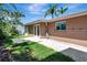 Backyard patio, featuring a brown stucco exterior, lush lawn and a partial view of blue skies at 5209 26Th W Ave, Bradenton, FL 34209