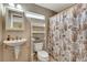 Bathroom features a pedestal sink, toilet, and shower with a seashell-themed shower curtain at 5209 26Th W Ave, Bradenton, FL 34209
