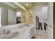 Well-lit bathroom with double sinks and a view into the kitchen at 5209 26Th W Ave, Bradenton, FL 34209